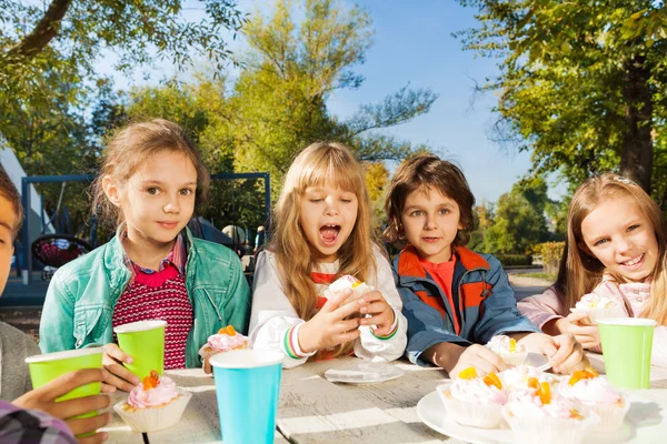 Kinder trinken Tee und essen Cupcakes — Stockfoto