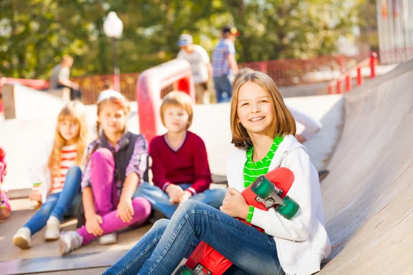 Girl with skateboard and friends — Stock Photo, Image