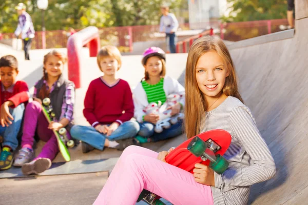 Girl with skateboard and friends — Stock Photo, Image
