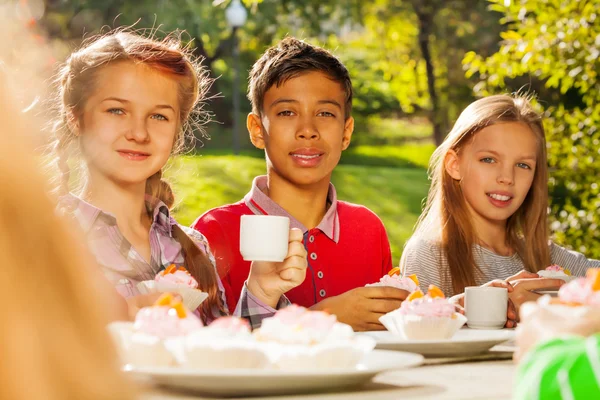 Grupo de crianças com copos e cupcakes — Fotografia de Stock