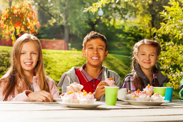 Grupp barn med koppar och cupcakes — Stockfoto