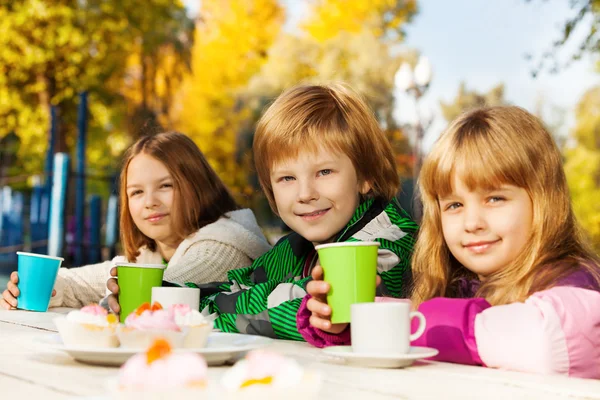 Smiling kids with tea cups — Stock Photo, Image