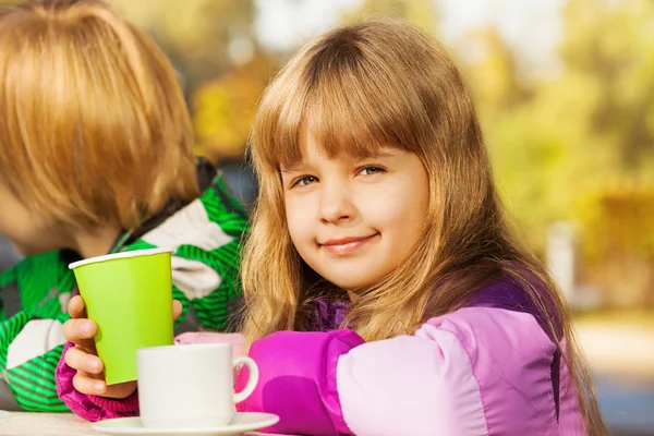 Blond tjej med gröna cup — Stockfoto