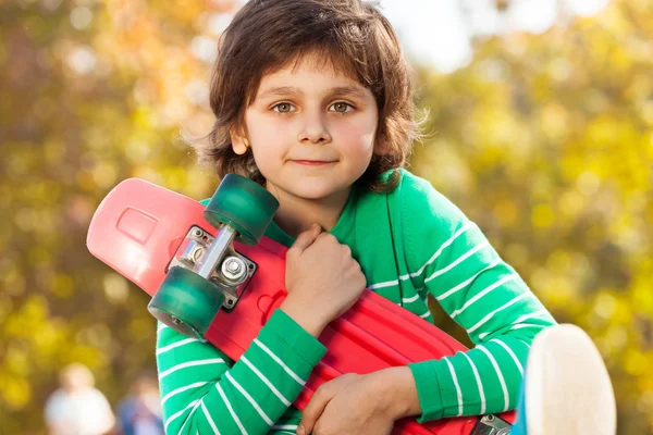 Щасливий хлопчик з червоним скейтбордом — стокове фото