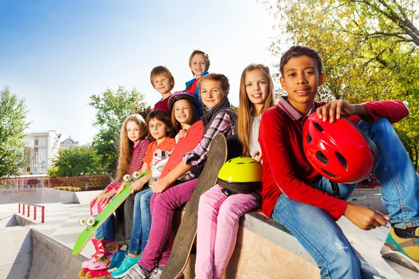 Friends sitting with skateboards — Stock Photo, Image