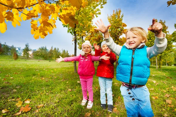 Kinderen spelen met gele bladeren — Stockfoto