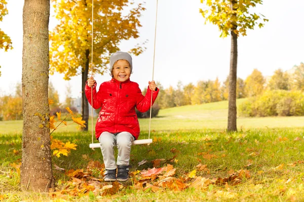 Girl sitting on swing in park — Stock Photo, Image