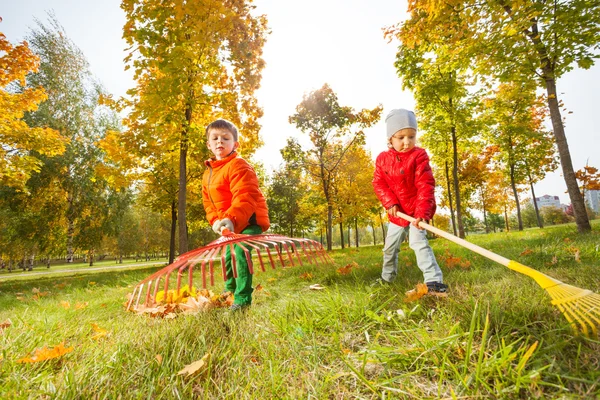 Jongen en meisje met het schoonmaken van gras — Stockfoto