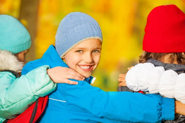 Back of friends hugging and wearing rucksacks — Stock Photo, Image