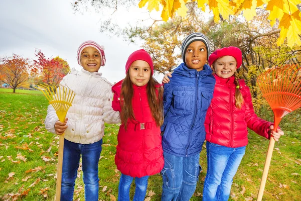 Enfants mignons avec des râteaux debout dans le parc — Photo