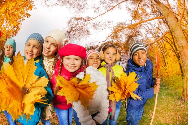 Niños felices con rastrillos y hojas — Foto de Stock