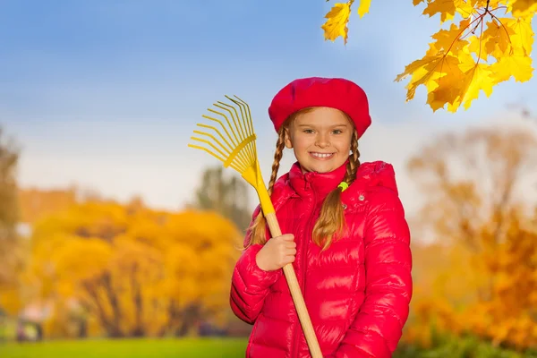 Beautiful smiling girl with rake — Stock Photo, Image