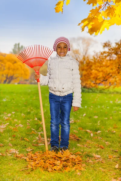 Smiling girl holds red rake — Stock Photo, Image