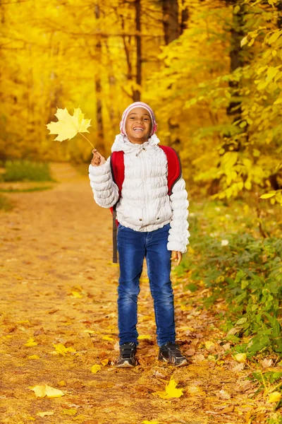 Menina com folha de bordo amarelo — Fotografia de Stock