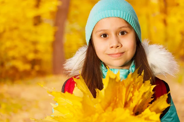 Schoolmeisje met bladeren bos — Stockfoto