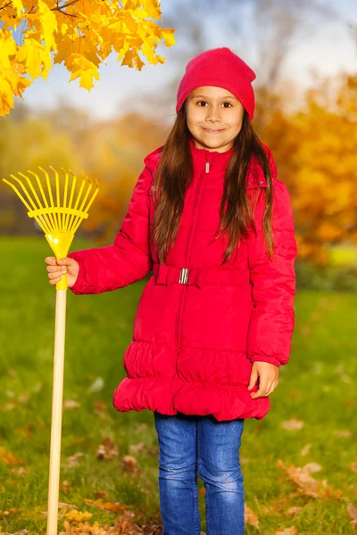 Girl with yellow rake — Stock Photo, Image