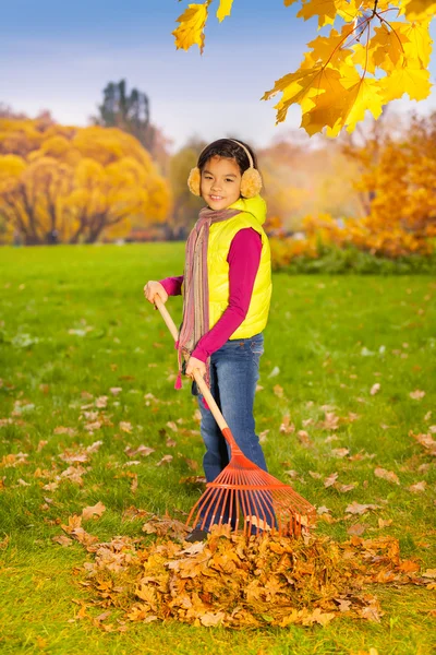 Asian girl with big red rake — Stock Photo, Image