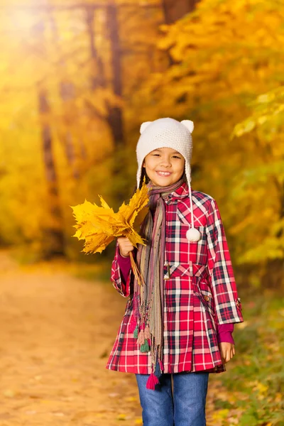 Ragazza con mazzo di foglie gialle — Foto Stock