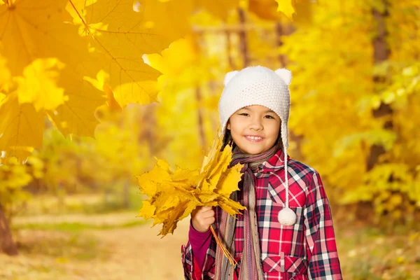 Fille avec un bouquet de feuilles jaunes — Photo