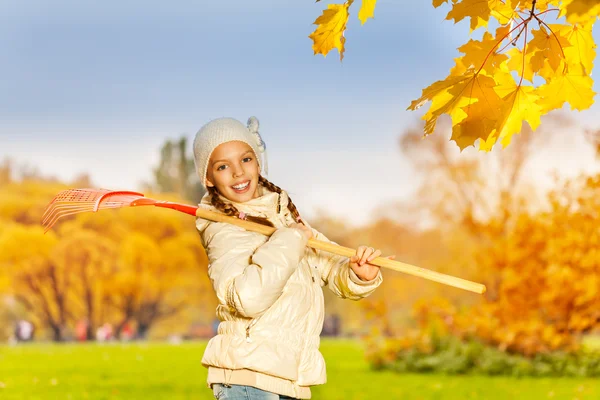 Beautiful happy girl with rake — Stock Photo, Image