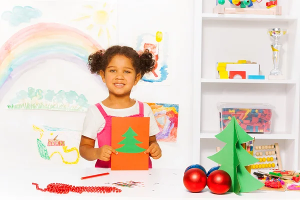 Menina detém cartão com árvore de Natal — Fotografia de Stock