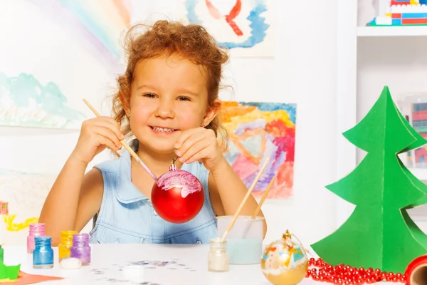 Girl paints New Year ball — Stock Photo, Image