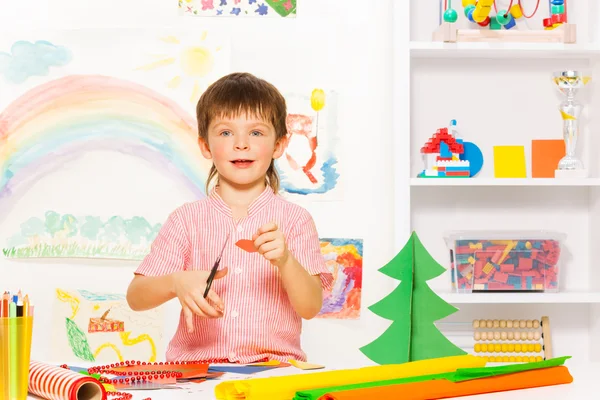 Niño sosteniendo tijeras y cartón —  Fotos de Stock
