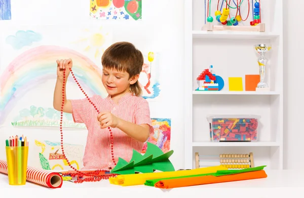 Niño sosteniendo cuentas con árbol de Navidad —  Fotos de Stock