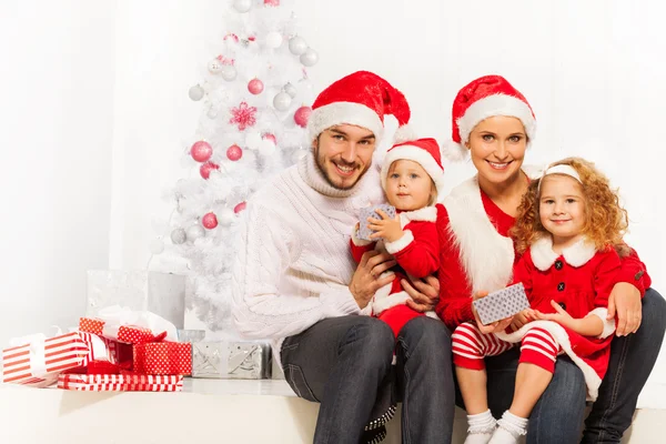 Familjen öppna klapparna under granen — Stockfoto