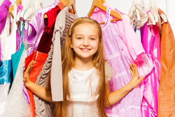 Meisje permanent tussen hangers — Stockfoto