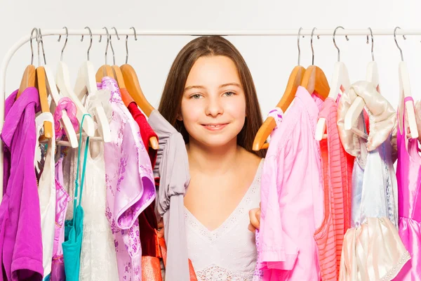 Girl  between hangers with dresses — Stock Photo, Image