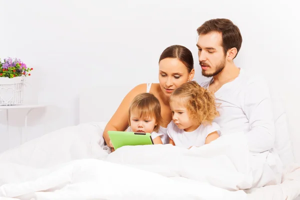 Padres e hijos jugando con la tableta — Foto de Stock