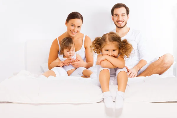 Famiglia seduta sul letto — Foto Stock