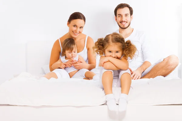 Família sentada na cama — Fotografia de Stock