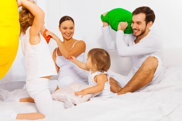 Föräldrar och barn som leker med kuddar — Stockfoto