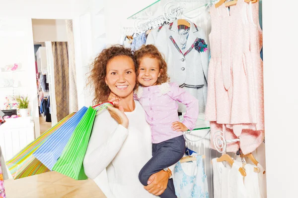 Mãe detém sacos de compras e filha — Fotografia de Stock