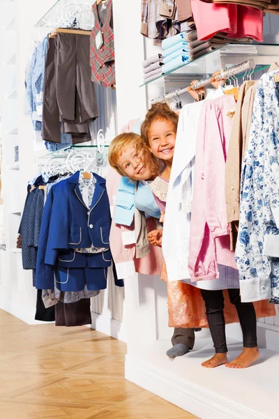 Chłopiec i dziewczynka grać zabawa w chowanego w ubrania — Zdjęcie stockowe