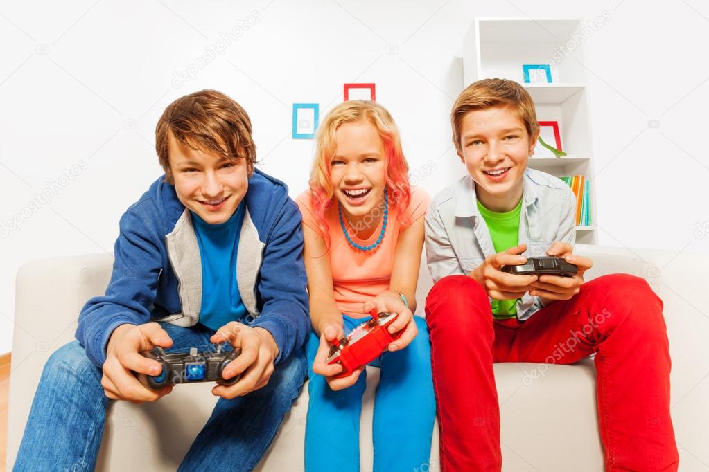 Happy teens hold joysticks
