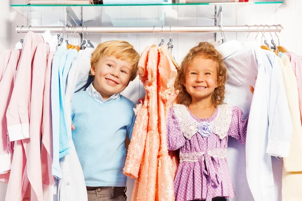 Jongen en meisje spelen verstoppertje in kleding — Stockfoto