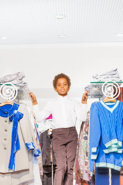 African boy between rows with clothes — Stock Photo, Image