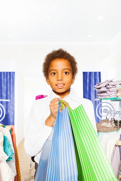 Niño africano con bolsas en la tienda —  Fotos de Stock