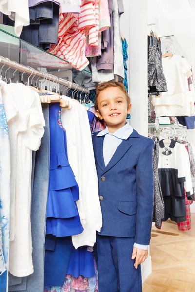 Boy standing near clothes — Stock Photo, Image
