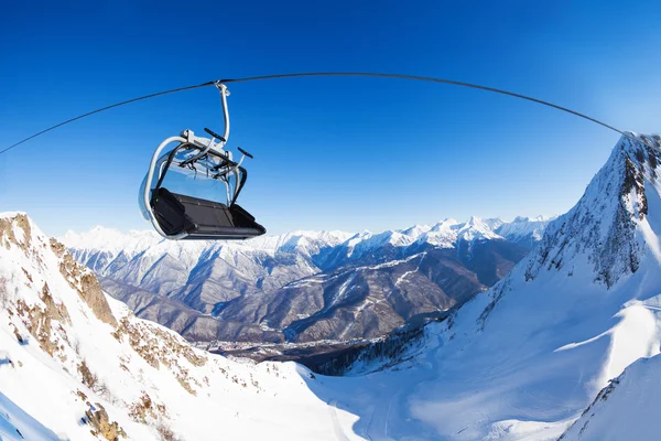 Cadeira no elevador de esqui sobre picos de montanha — Fotografia de Stock