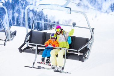 Ski lift üzerinde kaldırarak çocuk ile anne