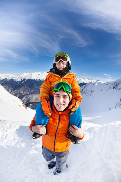 Niño sentarse en los hombros de los padres en las montañas —  Fotos de Stock