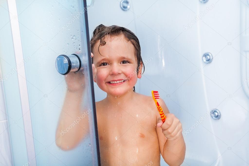 Boy with toothbrush showering in cabin