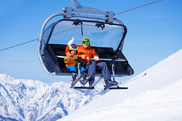 Boy and dad sit in chair lifting