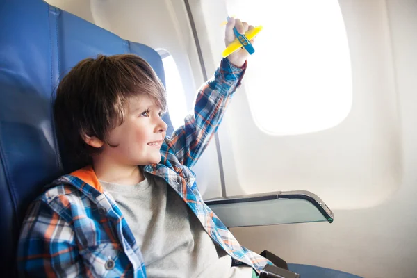 Junge mit Spielzeugflugzeug im Flugzeug — Stockfoto