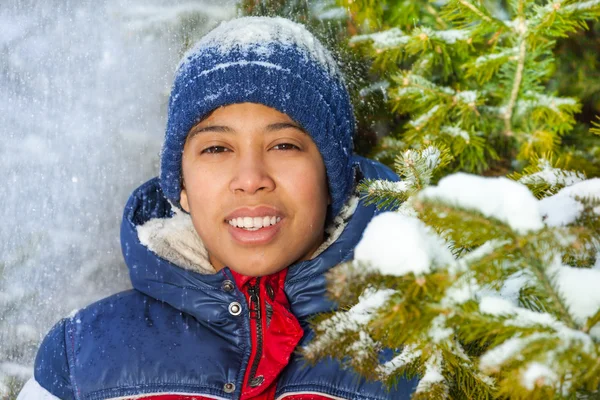 Rapaz sorridente na floresta com flocos de neve — Fotografia de Stock
