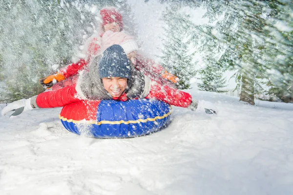 Vrienden op sneeuw tube in de winter — Stockfoto